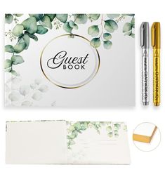 the guest book and pen are next to an open notepad with green leaves on it