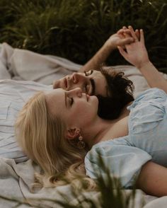 a woman laying on top of a bed next to a plant