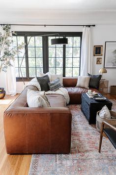 a living room filled with lots of furniture and decor on top of a wooden floor