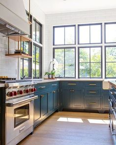 a kitchen with blue cabinets and stainless steel appliances