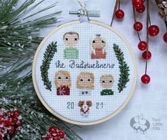 a cross stitch ornament with the names of people on it and christmas decorations