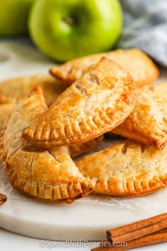 apple hand pies on a plate with cinnamon sticks and green apples in the background