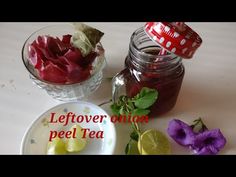 there is a jar of tea next to some flowers and lemons on the table