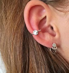 a close up of a person's ear with two piercings