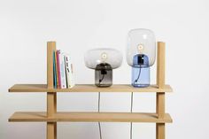 a wooden shelf with two glass lamps on it