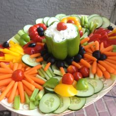 a platter filled with cucumbers, carrots, and other vegetables