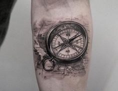 a man's arm with a compass tattoo on it