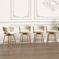 four chairs and a plant in front of a white wall