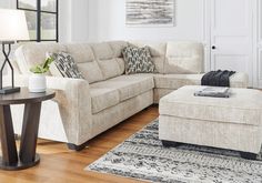 a living room filled with furniture on top of a hard wood floor covered in rugs