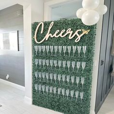 there is a green wall that has champagne glasses on it and the word cheers spelled in gold