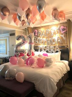 a bed with balloons and streamers in the shape of numbers on top of it