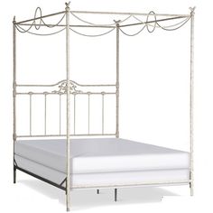 a white metal bed with four posts