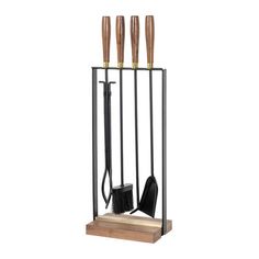 an iron and wood fireplace tool holder with four knives on it's sides, holding tools