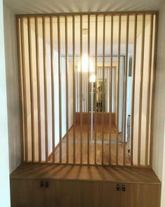 an empty room with wooden slats on the wall and a large mirror behind it