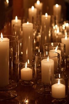 many lit candles are in glass vases