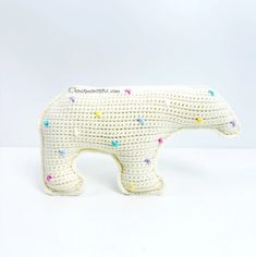 a crocheted polar bear with multicolored dots on it's body