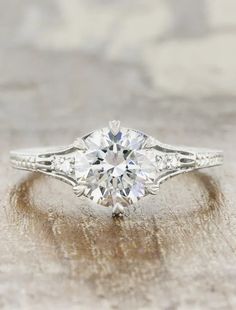 an antique style diamond engagement ring with side stones