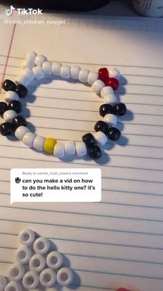 a bracelet made out of legos sitting on top of a notebook with the caption'can you make a wild on how to do the hello kitty one?'s so cute?