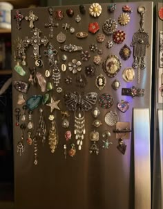 a refrigerator covered in lots of different types of earrings on it's side,