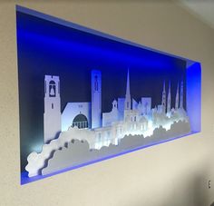 a blue and white wall with a cut out of a city on it's side