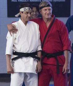 two men standing next to each other while wearing karate uniforms and holding their arms around one another