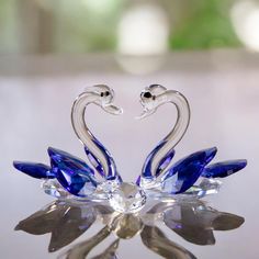 a glass swan figurine sitting on top of a table