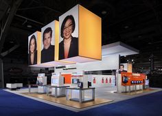 an exhibit booth with three large pictures hanging from the ceiling