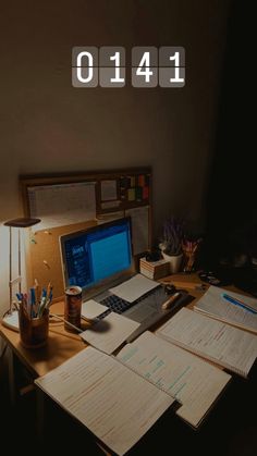 a laptop computer sitting on top of a wooden desk next to papers and pencils