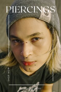 a young woman with piercings on her nose wearing a beanie and looking at the camera