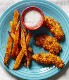 fried chicken and french fries on a blue plate with ranch dressing in a red bowl