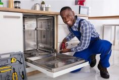 a man in blue overalls is opening the oven door and smiling at the camera