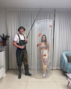 a man standing next to a woman holding a fishing rod in front of a fish net