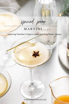 the martini is garnished with an orange peel and star anise on top