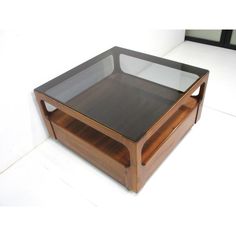 a glass and wood coffee table on white floor