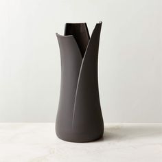 a gray vase sitting on top of a white table