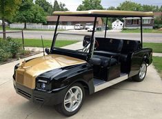 a black and gold golf cart parked in front of a house