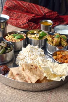 a metal tray filled with lots of different types of food on top of a table