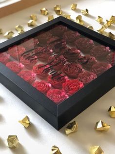 there is a black box with red roses in it and some gold stars around it