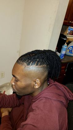 a man with dreadlocks sitting in a chair