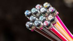 a close up view of several different colored pencils with the tops turned upside down