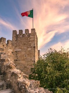 a flag flying on top of a stone castle