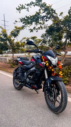 the motorcycle is parked on the side of the road next to some trees and bushes