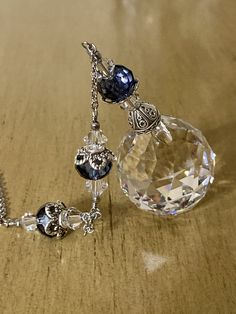 a close up of a necklace on a table with a key chain attached to it