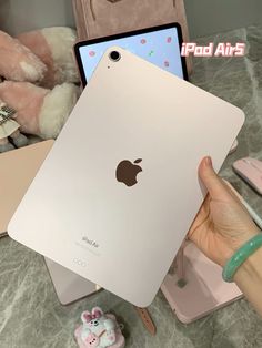 someone holding an ipad in their hand with the new model on display next to it