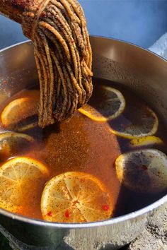 a pot filled with liquid and lemon slices