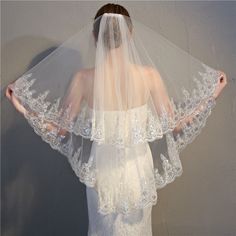 a woman wearing a veil with white lace on it