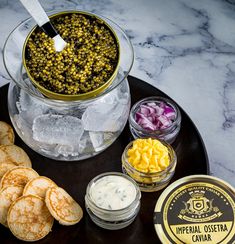 an assortment of food items on a plate with ice and crackers next to it