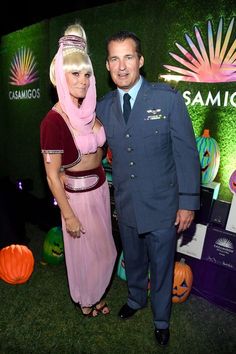 a man and woman dressed in costumes standing next to each other on the green carpet