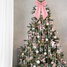 a decorated christmas tree with pink bows and ornaments