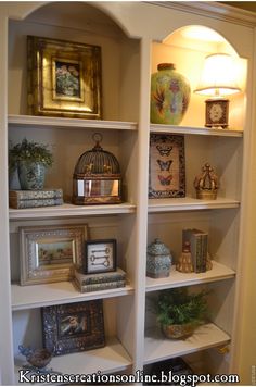 an open book shelf with pictures and other items on it